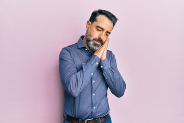 Middle age man with beard and grey hair wearing business clothes sleeping tired dreaming and posing with hands together while smiling with closed eyes.