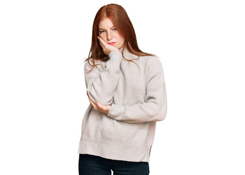 Young read head woman wearing casual winter sweater thinking looking tired and bored with depression problems with crossed arms.