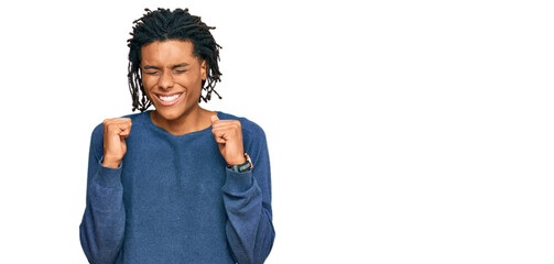 Young african american man wearing casual winter sweater excited for success with arms raised and eyes closed celebrating victory smiling. winner concept.