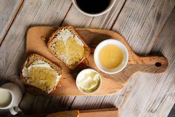 Top view on whole grain bread slices spred with butter and honey