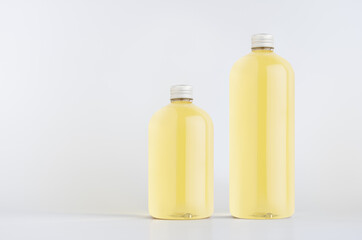 Set of two plastic tall and low bottles with orange drink, cooking oil or cosmetic produce, silver cap mockup on white background, template, copy space.