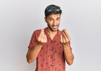 Naklejka premium Young handsome man wearing casual summer clothes doing money gesture with hands, asking for salary payment, millionaire business