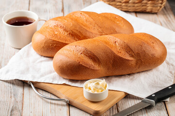 White loaf breads with butter and coffee on the wooden cutting board