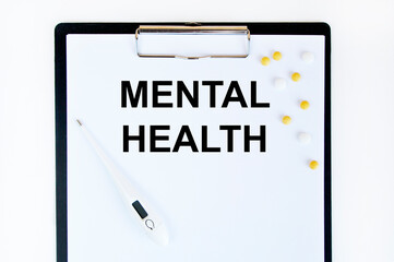 On the letter tablet is the text of Mental Health, next to the thermometer and yellow tablets.