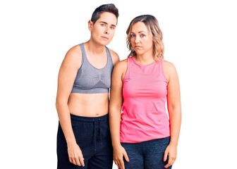 Fototapeta premium Couple of women wearing sportswear looking sleepy and tired, exhausted for fatigue and hangover, lazy eyes in the morning.
