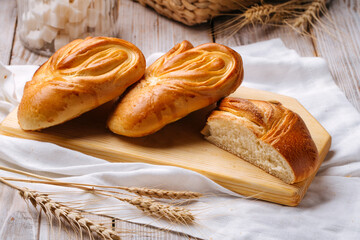 Side view on fresh baked heart shaped buns on the wooden board