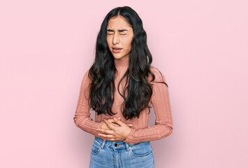 Hispanic teenager girl with dental braces wearing casual clothes with hand on stomach because nausea, painful disease feeling unwell. ache concept.