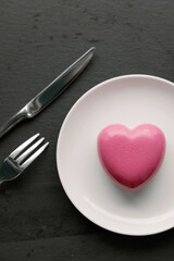 cake in heart shape. Red cupcake in the shape of a heart on a dark gray background. Valentine's Day