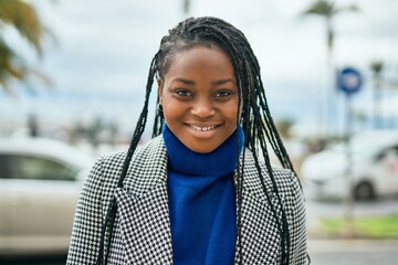 Young african american businesswoman smiling happy standing at the city.