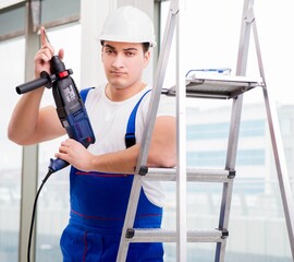 Repairman working with power drill in workshop