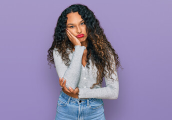 Young hispanic woman with curly hair wearing casual clothes thinking looking tired and bored with depression problems with crossed arms.