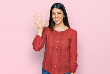 Young hispanic woman wearing casual clothes showing and pointing up with fingers number five while smiling confident and happy.