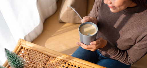 Closeup image of a beautiful young asian woman drinking hot coffee at home in the morning