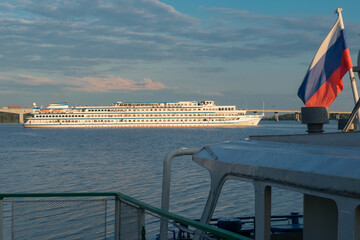 Fototapeta na wymiar A cruise ship departs from the pier on the Volga river in the city of Kostroma on a summer evening