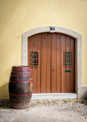 Barrel next to the door on the yellow wall in Sintra, Portugal