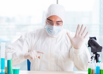 Young chemist pressing virtual buttons in lab