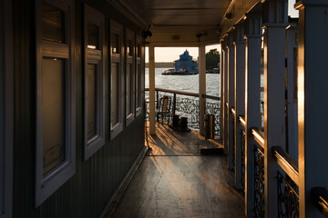 Table and chairs in a cafe on the river embankment on a summer evening at sunset