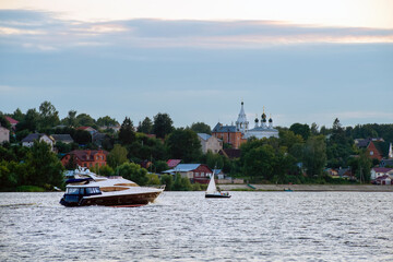 Fototapeta na wymiar Speedboat and sailing boat on a summer evening at sunset on the Volga River