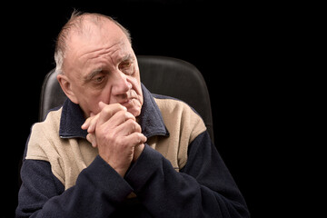 portrait vieil homme recroqueviller de chagrin dans son fauteuil sur fond noir