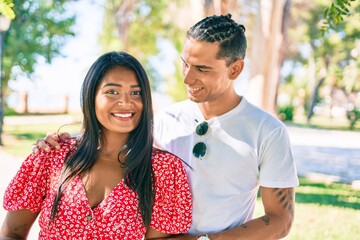 Fototapeta premium Young latin couple smiling happy and hugging at the park.