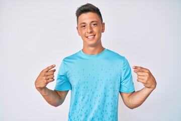 Young hispanic boy wearing casual clothes looking confident with smile on face, pointing oneself with fingers proud and happy.