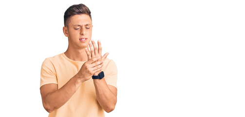 Fototapeta premium Young handsome man wearing casual clothes suffering pain on hands and fingers, arthritis inflammation