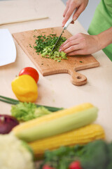 Close-up of human hands cooking vegetables salad in kitchen. Healthy meal and vegetarian concept