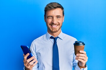 Handsome caucasian business man using smartphone and drinking a cup of coffee winking looking at...