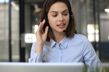 Female customer support operator with headset and smiling.