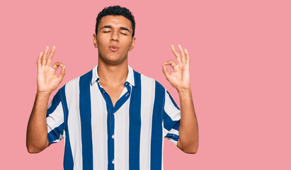Young arab man wearing casual clothes relax and smiling with eyes closed doing meditation gesture with fingers. yoga concept.