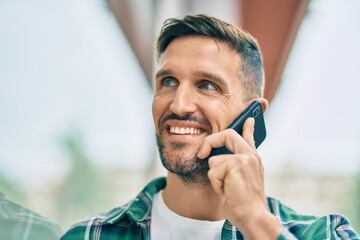 Young caucasian man smiling happy talking on the smartphone at the city.