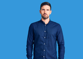 Young handsome man wearing casual shirt looking sleepy and tired, exhausted for fatigue and hangover, lazy eyes in the morning.