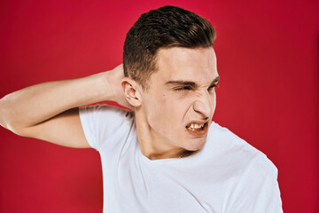 Obraz premium Emotional man white t-shirt displeased facial expression red isolated background cropped view