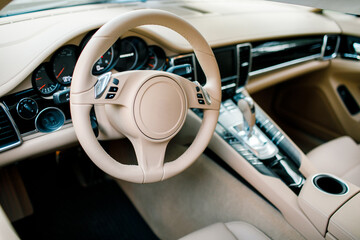 bright luxury interior of the car-steering wheel, gear lever and dashboard