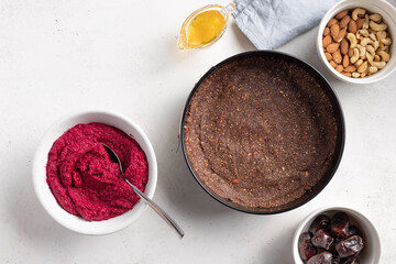 base for vegan cake and cream of beets, nuts in bowl. Gluten free, sugar free vegan food. White background. copy space.