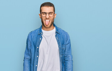 Young caucasian man wearing casual clothes sticking tongue out happy with funny expression. emotion concept.