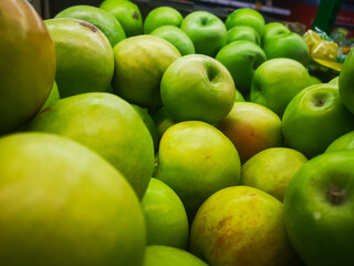 selling green apples in a cardboard box by weight in a supermarket