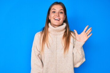 Beautiful caucasian woman wearing wool winter sweater showing and pointing up with fingers number five while smiling confident and happy.