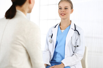 Fototapeta premium Woman - doctor consults her female patient in clinic. Medicine concept