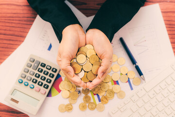 business woman hold many coins in both hands on growth graph and chart with calculator count money...