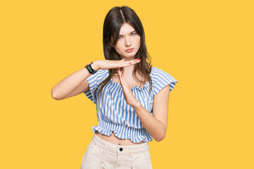 Young beautiful caucasian girl wearing casual clothes doing time out gesture with hands, frustrated...