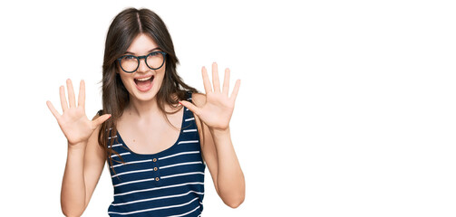Obraz na płótnie Canvas Young beautiful caucasian girl wearing casual clothes and glasses showing and pointing up with fingers number ten while smiling confident and happy.