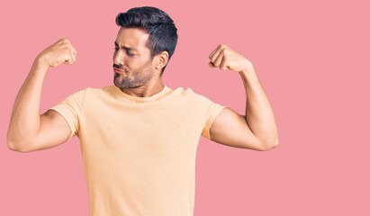 Young hispanic man wearing casual clothes showing arms muscles smiling proud. fitness concept.