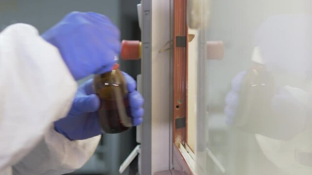 Close-up of the hands of a scientist doing a laboratory experiment ina Safety Cabinet. Research concept. Selective focus.