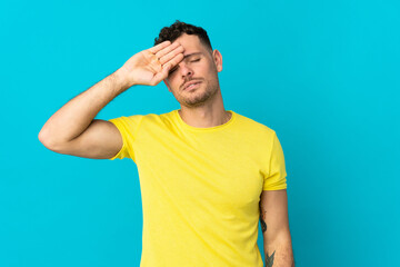 Young caucasian handsome man isolated on blue background with tired and sick expression