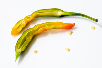 a half cut cayenne chilli pepper showing the inside and seeds isolated with a white background.