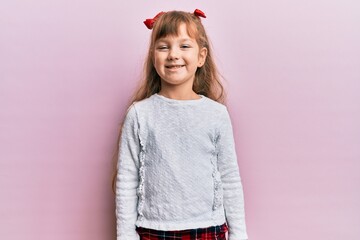 Little caucasian girl kid wearing casual clothes with a happy and cool smile on face. lucky person.