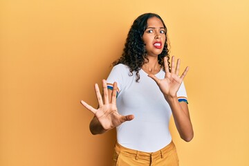 Young african american girl wearing casual clothes afraid and terrified with fear expression stop...