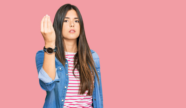 Young brunette woman wearing casual clothes doing italian gesture with hand and fingers confident expression