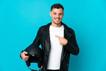 Caucasian man with a motorcycle helmet isolated on blue background with surprise facial expression